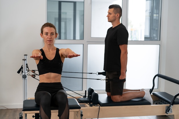 Personne s'entraînant au gymnase avec un superviseur