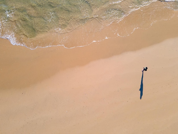 Personne seule debout sur le sable alors que l'eau se précipite