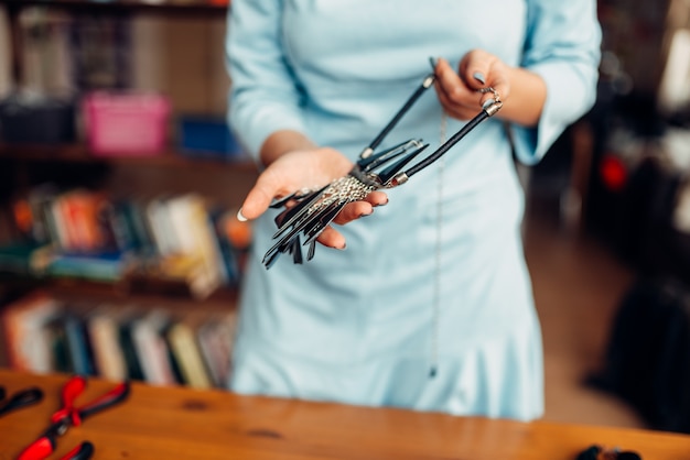 Personne de sexe féminin détient un collier fait main, des travaux d'aiguille. Artisan féminin sur le lieu de travail en studio d'art