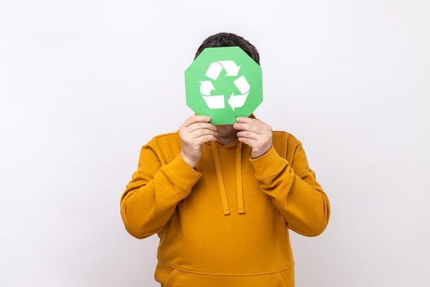 Personne de sexe masculin se cachant derrière le panneau de recyclage vert tri des ordures et protection de l'environnement