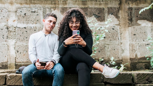 Personne suspecte espionnant le téléphone de sa petite amie Gars jaloux espionnant le téléphone de sa petite amie Petit ami méfiant espionnant le téléphone de sa petite amie