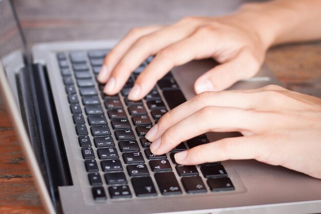 Photo une personne tapant sur un clavier d'ordinateur portable avec les lettres tm sur le clavier