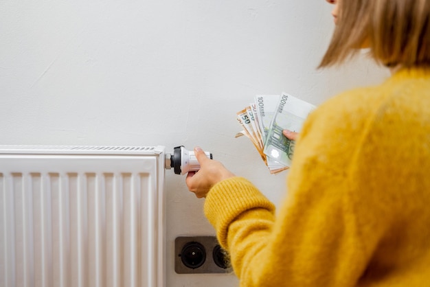 Personne Tenant Des Billets En Euros Près Du Radiateur