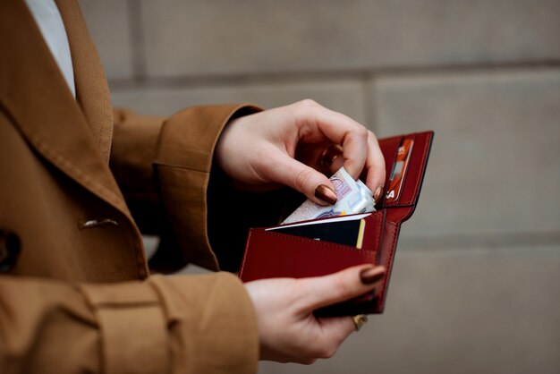 Personne tenant une carte et de l'argent dans les mains