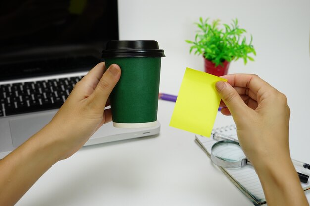 Une personne tenant du café et des notes