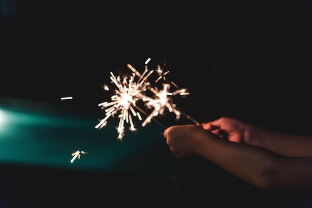 Personne tenant des étincelles la nuit