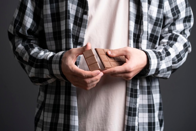 Une personne tenant et freinant une barre de chocolat noir