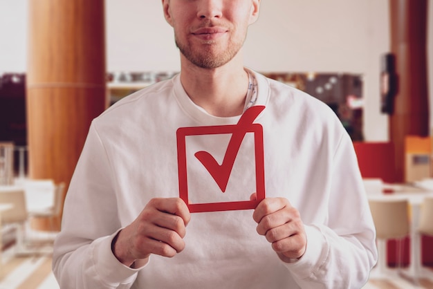Une personne tenant une icône de contrôle du cadre de vote concept de vote et démocratie électorale au sein du gouvernement
