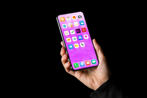Photo personne tenant à la main un téléphone portable avec des icônes d'application sur l'écran d'accueil
