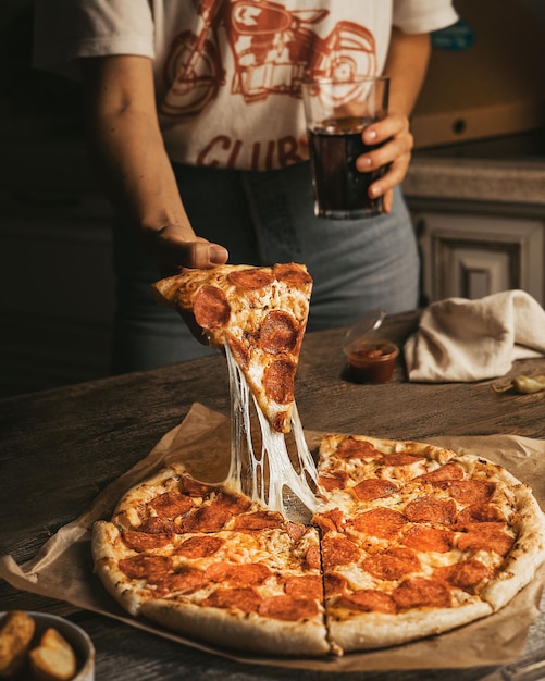 personne tenant une pizza dans la cuisine