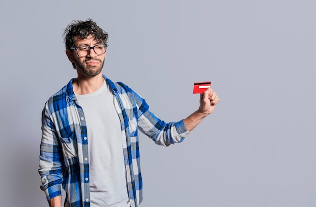 Personne tenant et regardant la carte de crédit avec méfiance