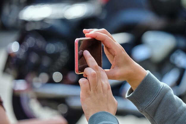 Personne tenant un smartphone et prendre des photos dans la rue.