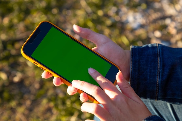 Une personne tenant un téléphone avec un écran vert