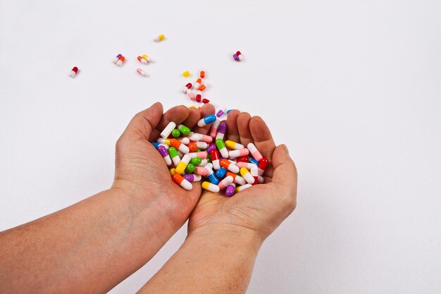 Une personne tient une poignée de perles colorées dans ses mains.