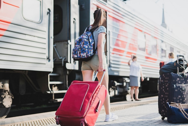 Une personne tirant le sac à bagages à la gare