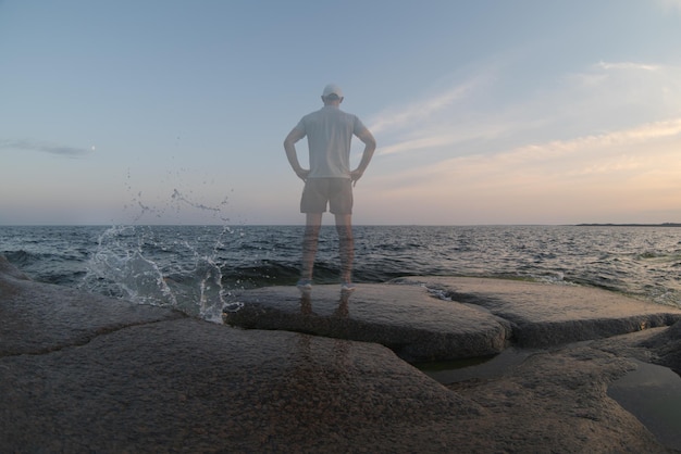 Une personne transparente se tient au bord de la mer Vue arrière