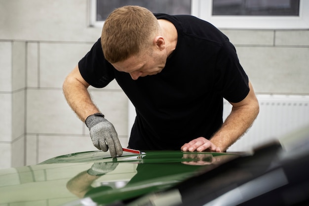 Personne travaillant sur l'habillage de voiture