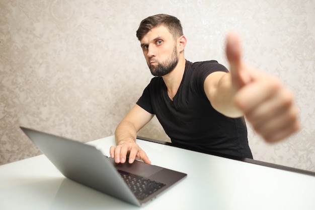 une personne travaillant sur un ordinateur montre des gestes de la main