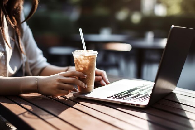 Une personne travaille sur un ordinateur portable tout en étant assise sur une terrasse de café en plein air ai générative