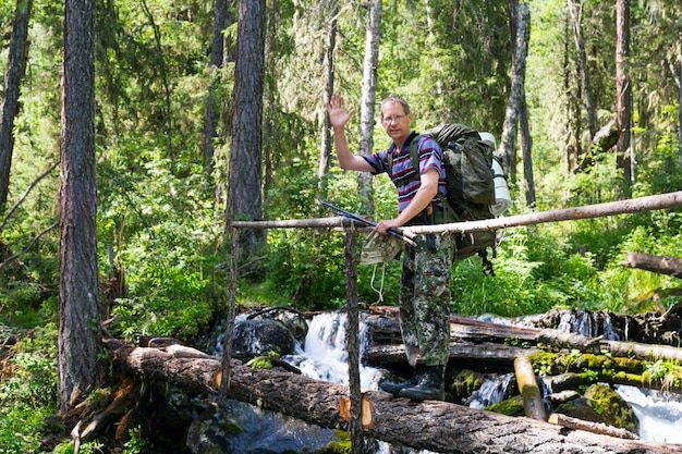 Une personne traverse la rivière sur un journal.