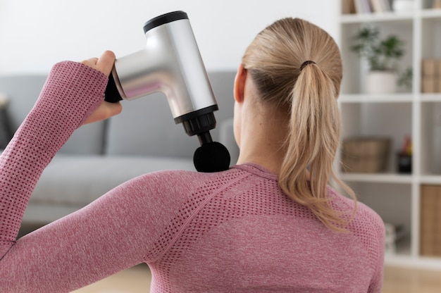 Personne utilisant un pistolet de massage