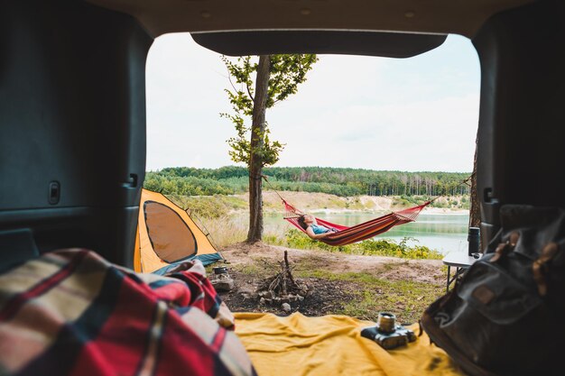 Photo personne vue couple se reposant au camping femme allongée dans un hameau avec une belle vue sur le lac forestier