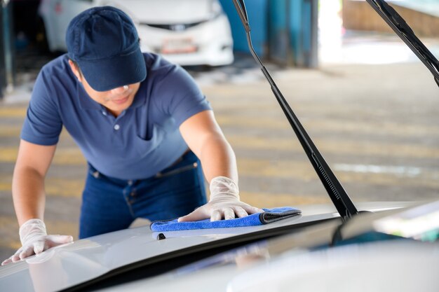 Le personnel du service de lavage de voitures nettoie leurs voitures avec des chiffons en microfibre. Détails et concept de valet Mise au point sélective Vue rapprochée