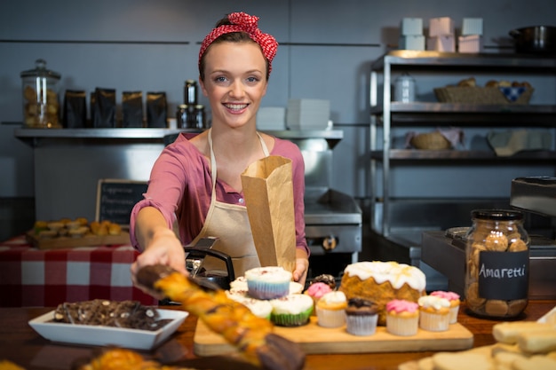 Personnel Féminin Emballant Des Aliments Sucrés Dans Un Sac En Papier