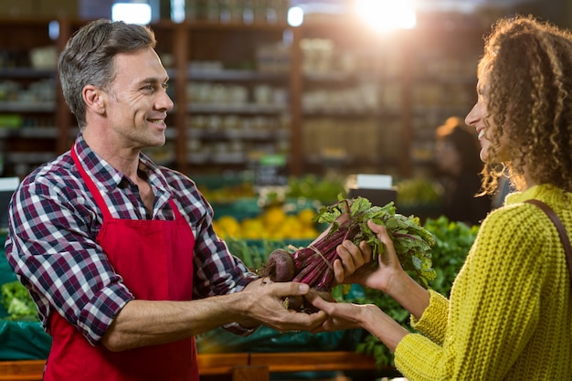 Personnel masculin souriant aidant une femme à faire l'épicerie