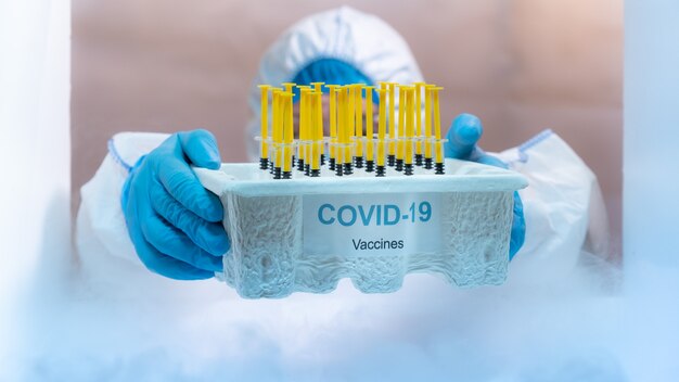 Personnel médical distribuant le plateau de vaccin covid-19 à l'intérieur du congélateur. Concept de soins de santé et médical