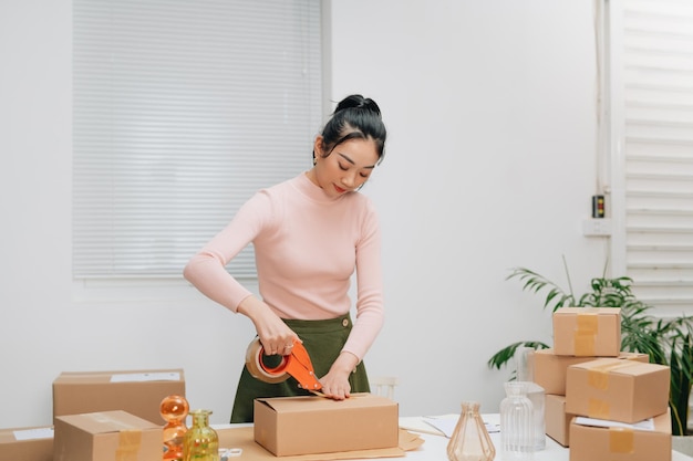 Le personnel utilise le ruban adhésif pour emballer les marchandises du colis au client