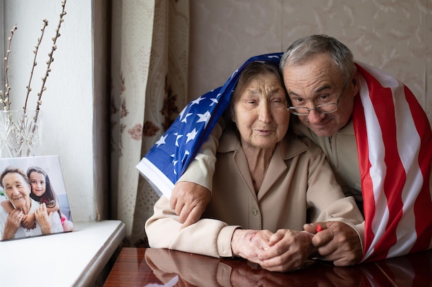 Personnes âgées avec le drapeau américain à la maison.