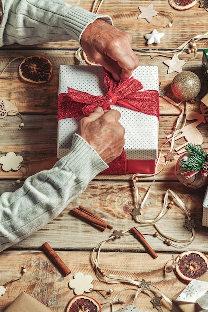 Personnes âgées mans mains emballage cadeaux de Noël