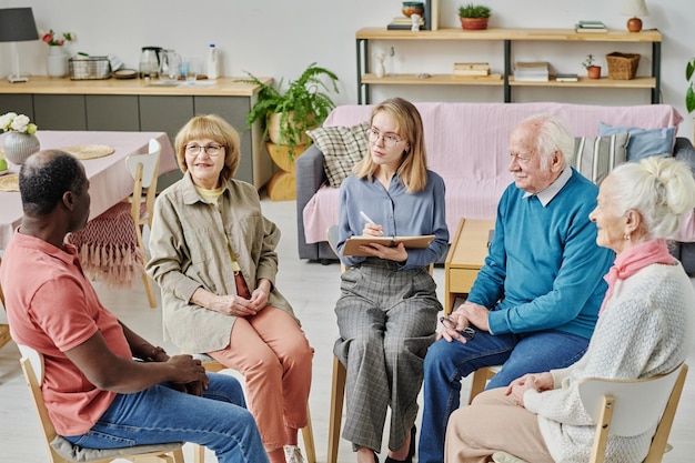Personnes âgées parlant à un psychothérapeute pendant une séance de psychothérapie dans une maison de retraite