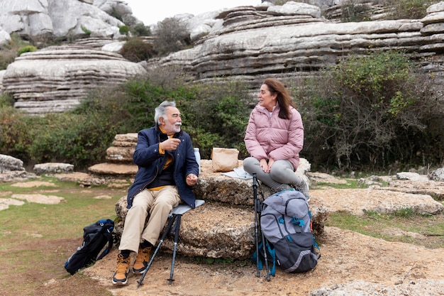 Personnes âgées pleines avec des sacs à dos dans la nature