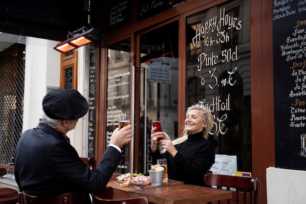 Personnes âgées souriantes à coup moyen au bistro