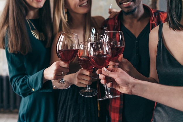 Les personnes appréciant les boissons au café. Amis au bar grillant du vin et souriant