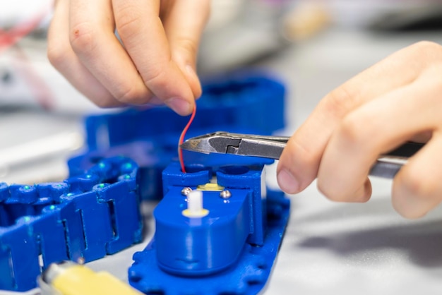 Les personnes assemblent à la main une machine robotique en plastique b