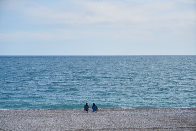 Personnes assises paisibles au bord de la mer