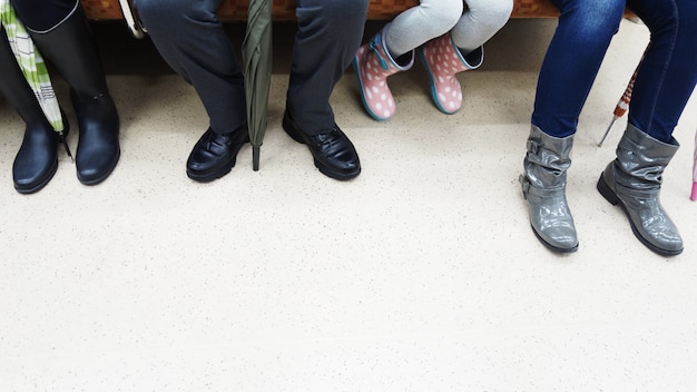 Les personnes assises portent des chaussures différentes dans un train.