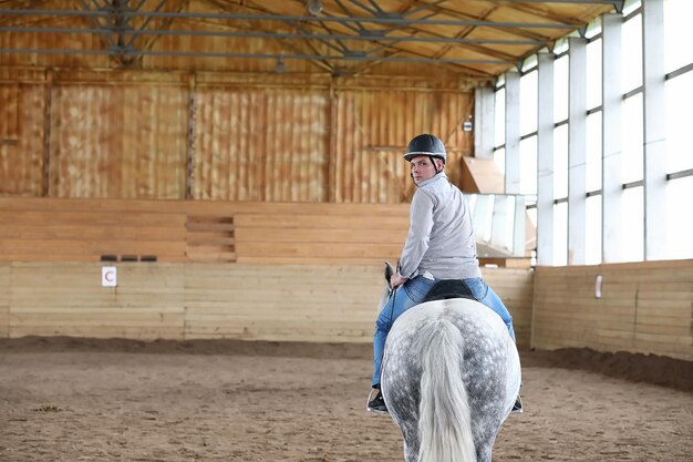 Personnes sur un cheval s'entraînant dans une arène en bois