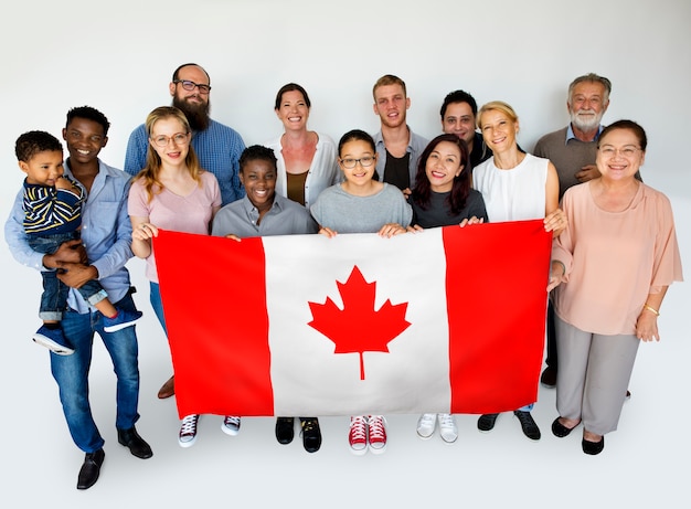 Personnes dans un groupe tenant un drapeau national et posant pour une séance photo