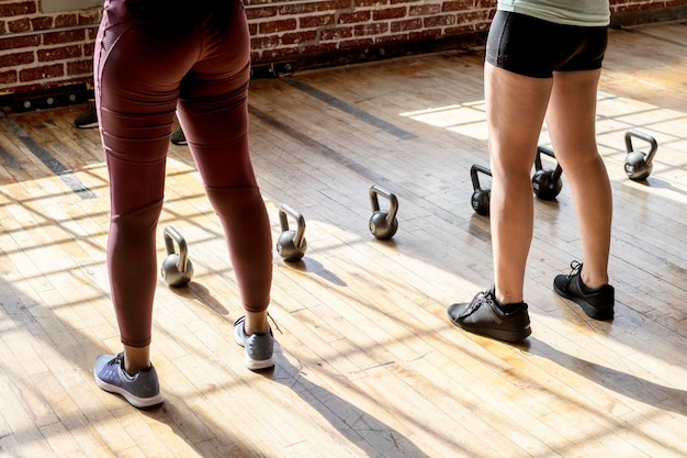 Photo personnes debout près des kettle bells dans la salle de sport