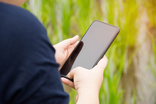 personnes détenant un smartphone avec le fond de la nature.