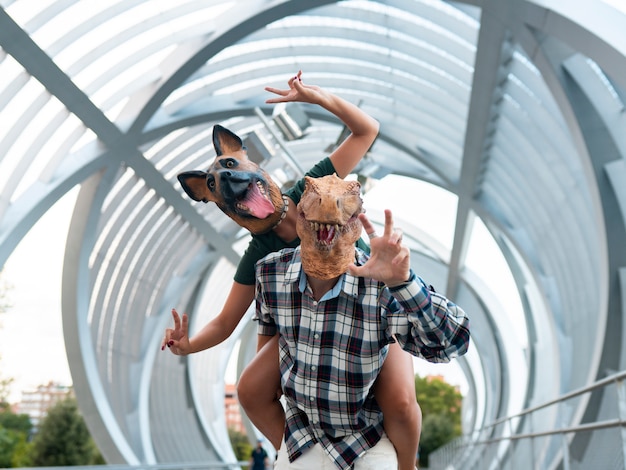 personnes élégantes couple de mode portant t-rex et masque de chien