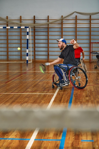 Personnes en fauteuil roulant jouant au tennis sur le court Tennis en fauteuil roulant