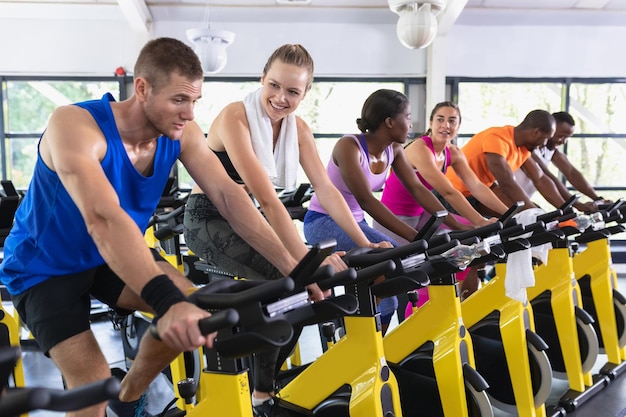 Photo des personnes en forme s'entraînent sur un vélo d'exercice dans un centre de remise en forme