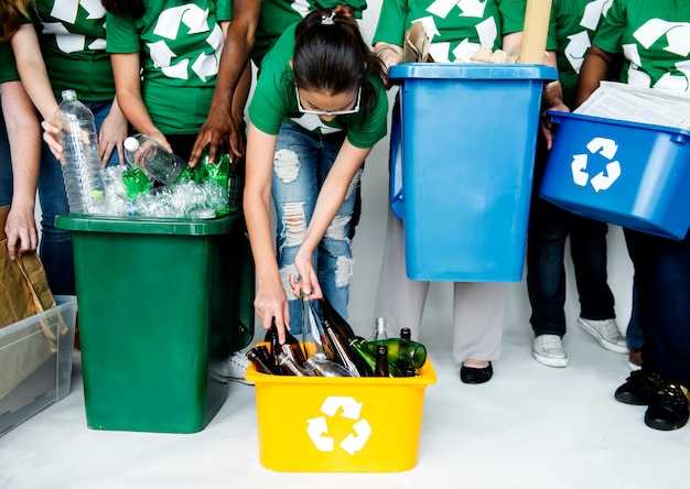 Des personnes d&#39;un groupe aidant ensemble à préparer des bouteilles à recycler