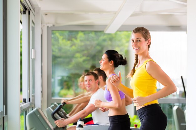 Personnes en gymnastique sportive sur tapis roulant en cours d&#39;exécution