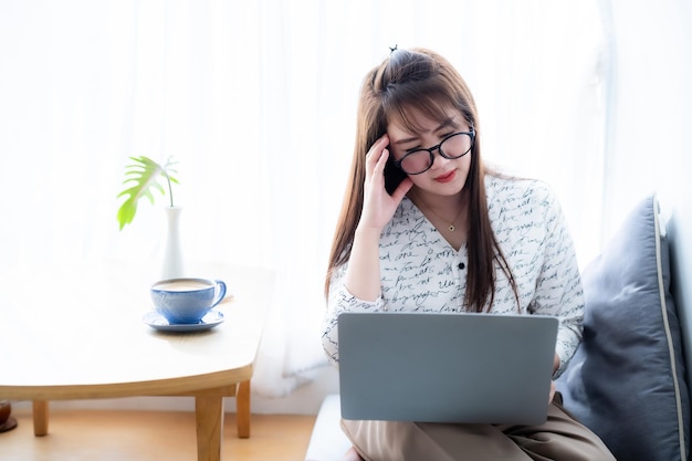 Photo personnes indépendantes stressées femmes d'affaires asiatiques ayant des maux de tête tout en travaillant en utilisant un ordinateur portable